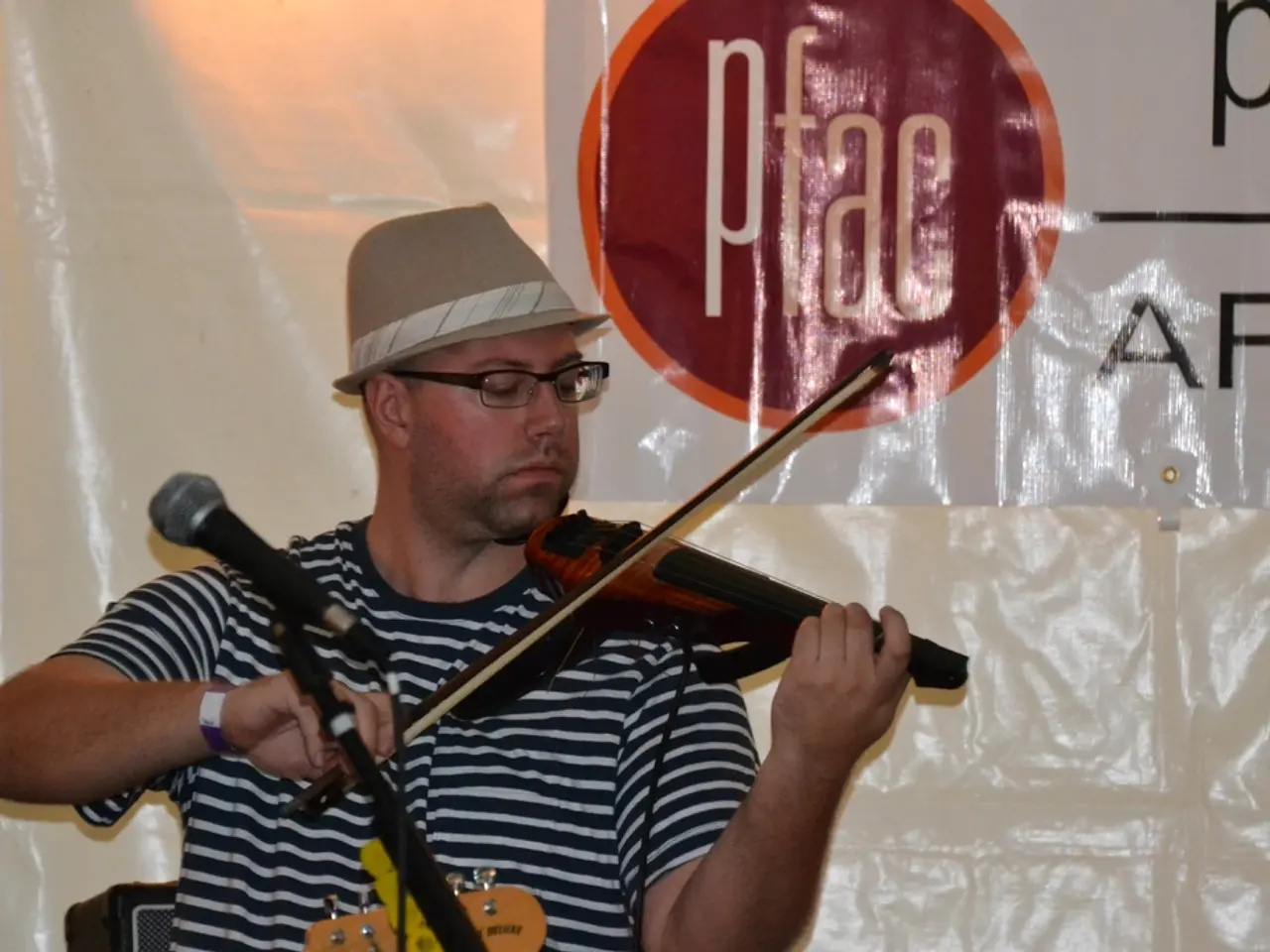 In this picture there is a man who is playing a violin. There is a mic.