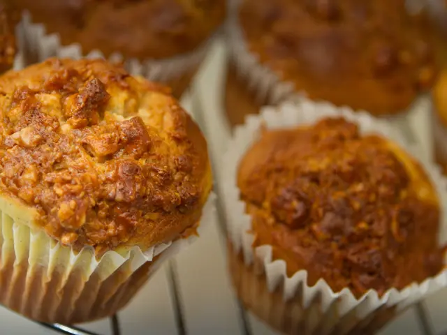 There are some cupcakes are kept on a steel grill.