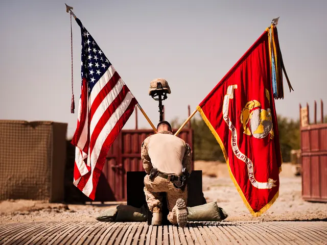 In the foreground of this image, there is a man kneel downing on one knee in front of a gun, helmet...
