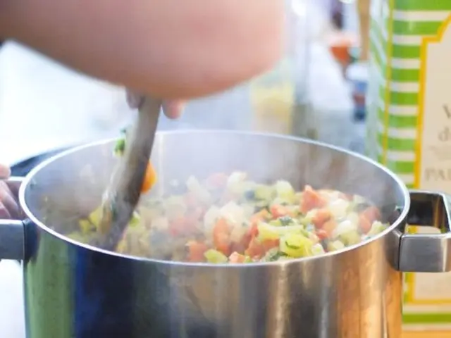 In this image we can see two vessels with food items in it on the stove. At the top of the image...