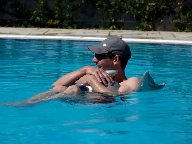 In this picture we can see a man with the goggles and a cap and the man is holding an inflatable...