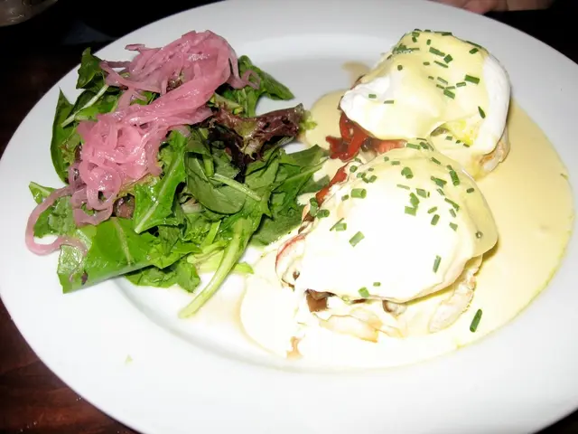 In this image we can see some food containing spinach leaves, cream and the sauce in a plate placed...