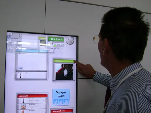 In this image we can see a person wearing spectacles operating a monitor screen of a device with...